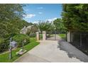 Private gated entrance features meticulously manicured landscaping leading to the home at 2225 Johnson Ferry Rd., Marietta, GA 30062