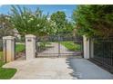 Elegant gated entrance with stone pillars adds security and curb appeal to the property at 2225 Johnson Ferry Rd., Marietta, GA 30062