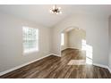 Open living room features elegant wood floors, vaulted ceilings, and decorative lighting at 3641 Oakleaf Pass, Fairburn, GA 30213