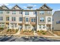 Exterior view of brick and siding townhomes with landscaped yards and covered entryways at 967 Allegro Park, Marietta, GA 30067