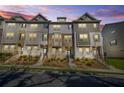 Exterior shot of townhomes at dusk, featuring brick, siding, landscaped yards and covered entryways at 967 Allegro Park, Marietta, GA 30067
