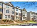 Exterior view of multi-story townhomes, with landscaped front yards and walkways leading to covered entryways at 967 Allegro Park, Marietta, GA 30067