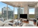 Airy living room featuring floor-to-ceiling windows offering city views, hardwood floors, and a modern chandelier at 860 Peachtree Ne St # 2001, Atlanta, GA 30308