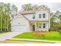Beautifully designed two-story home with white siding, lush lawn, and a two-car garage at 142 Henley St, Canton, GA 30114