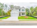 Beautifully designed two-story home with white siding, lush lawn, and a two-car garage at 142 Henley St, Canton, GA 30114
