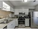 Well-lit kitchen featuring modern stainless steel appliances, white cabinets, and granite countertops at 6606 Wellington Sq, Norcross, GA 30093