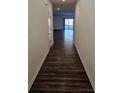 Long hallway with dark hardwood floors, white walls and white trim at 656 Friesland Dr, Hampton, GA 30228