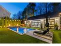 Beautiful backyard pool with an integrated fire feature and lounge chairs for relaxing poolside at 7165 Cordery Rd, Cumming, GA 30040
