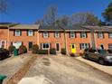 Brick townhomes feature parking, colorful doors, and maintained landscaping, adding curb appeal at 1098 Westfield Se Trce, Smyrna, GA 30082