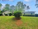 Well maintained lawn with mature landscaping in front of a cozy home under a bright blue sky at 1950 S Inlet, Marietta, GA 30066