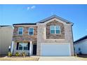 Charming two-story home with stone and brick exterior, a manicured lawn, and a two-car garage at 2268 Redfern Rd, Dacula, GA 30019