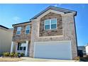 Charming two-story home with stone and brick exterior, a manicured lawn, and a two-car garage at 2268 Redfern Rd, Dacula, GA 30019
