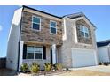 Charming two-story home with stone and brick exterior, a manicured lawn, and a two-car garage at 2268 Redfern Rd, Dacula, GA 30019
