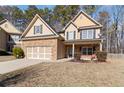 Charming two-story home boasts a stone and siding exterior with a two-car garage and well-maintained front yard at 3158 Arbor Oaks Way, Snellville, GA 30039