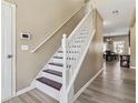 Bright foyer with hardwood floors, showcasing the staircase with white railing and access to the dining area at 3158 Arbor Oaks Way, Snellville, GA 30039