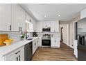 Modern kitchen featuring white cabinets, quartz countertops, stainless steel appliances, and stylish backsplash at 3540 Honeycomb Se Dr, Conyers, GA 30094