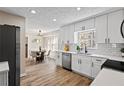 Bright, updated kitchen with white cabinets, stainless steel appliances, quartz counters, and a view into the dining area at 3540 Honeycomb Se Dr, Conyers, GA 30094