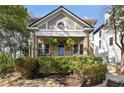Inviting home exterior featuring a charming covered porch with decorative hanging plants and well-maintained greenery at 750 Clemont Ne Dr, Atlanta, GA 30306