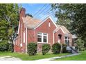 Side view of red brick home with chimney, trimmed bushes, and well-maintained lawn on a sunny day at 1709 Rogers Sw Ave, Atlanta, GA 30310