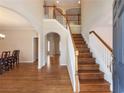 Elegant foyer features hardwood floors, staircase with white railings and wood trim, and arched doorways at 1755 Presidents Dr, Lawrenceville, GA 30043