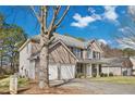 Two-story brick home features an attached two-car garage and a covered front porch at 165 Kentwood Springs Dr, Hampton, GA 30228