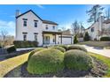 Beautiful two-story home featuring a covered porch, attached garage, and mature landscaping at 5065 Timberbridge Ln, Johns Creek, GA 30022