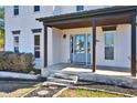 Inviting entryway showcasing a light blue front door, covered porch, and decorative landscaping at 5065 Timberbridge Ln, Johns Creek, GA 30022