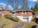 Inviting brick home featuring an attached garage and a well maintained lawn at 853 Erin Sw Ave, Atlanta, GA 30310