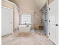 Elegant bathroom featuring a soaking tub, marble tile flooring, and a glass-enclosed shower at 330 Tupelo Trl, Canton, GA 30114
