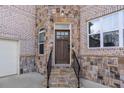 Inviting front entrance with a wood door, stone accents, and steps leading to the entrance at 4834 Neal Rdg, Atlanta, GA 30349