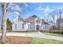 Stately two-story residence with a well-kept lawn, arched windows, and a picturesque balcony at 7015 Polo Dr, Cumming, GA 30040