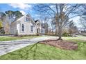 Beautiful two-story home with a long driveway, lush lawn, and well-maintained landscaping at 7015 Polo Dr, Cumming, GA 30040