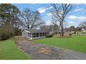 Exterior view of a home with a screened-in porch, complemented by a green lawn and mature trees at 2880 Hall Se Dr, Smyrna, GA 30082