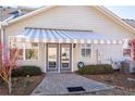 Cozy outdoor space featuring a striped awning covering the patio, with manicured shrubs at 312 Overview Dr, Canton, GA 30114