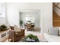 Bright and airy living room with hardwood floors, stylish furniture, and an open doorway to the dining area at 1563 Westwood Sw Ave, Atlanta, GA 30310