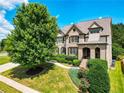 Well-manicured front yard with mature trees and shrubs highlighting the home's traditional architecture at 201 Beacon Cv, Canton, GA 30114