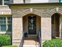 The home features a covered brick entryway with an arched opening and a black front door at 201 Beacon Cv, Canton, GA 30114