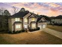 An aerial view of a two-story home featuring a well-maintained lawn and a driveway leading to a two-car garage at 4526 Warren Mill Trl, Ellenwood, GA 30294