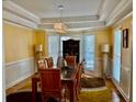 Formal dining room features a tray ceiling, chandelier, and bay window at 1230 Mars Hill Nw Rd, Acworth, GA 30101