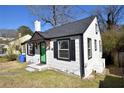 This home features a gray roof, black trim, a green door, and white painted siding at 232 Mathewson Sw Pl, Atlanta, GA 30314