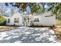 Charming home featuring a large driveway, flower boxes on windows, and white painted brick at 1428 Pinehurst Sw Dr, Atlanta, GA 30311