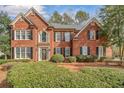 Two-story brick home featuring black shutters and a well-manicured front lawn at 1558 Amberwood Creek Nw Dr, Kennesaw, GA 30152