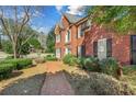 Charming brick home with manicured bushes and brick walkway at 1558 Amberwood Creek Nw Dr, Kennesaw, GA 30152