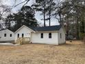 Charming single-story home with new white siding, black roof, and a wood porch at 5385 Booker T Dr, Morrow, GA 30260
