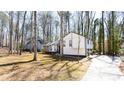 Exterior of home featuring modern updates, nestled among mature trees and a driveway, offering serene suburban living at 5199 Mainstreet Park Dr, Stone Mountain, GA 30088
