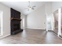 Stunning living room boasts a fireplace with stone accents, vaulted ceiling, and LVP flooring at 5199 Mainstreet Park Dr, Stone Mountain, GA 30088