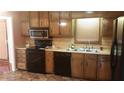 Functional kitchen featuring wood cabinets, black appliances, and ample counter space at 7356 Caribou Trl, Riverdale, GA 30296