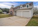 Side view of a two-story home with a two-car garage and a well-maintained front yard at 5589 Claridge Cir, Lithonia, GA 30038