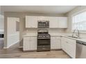 Bright kitchen features white cabinets, stainless steel appliances, and a modern design at 5589 Claridge Cir, Lithonia, GA 30038