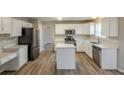 Modern kitchen features stainless steel appliances, an island, hardwood floors and plenty of counter space at 4060 Rockmill Cv, Ellenwood, GA 30294